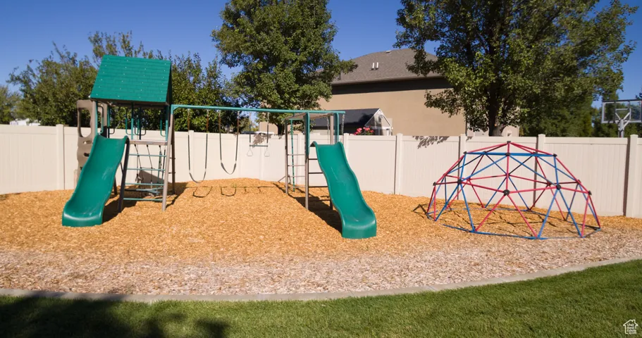 View of jungle gym with a fenced backyard