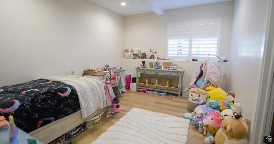 Bedroom featuring wood finished floors and beam ceiling