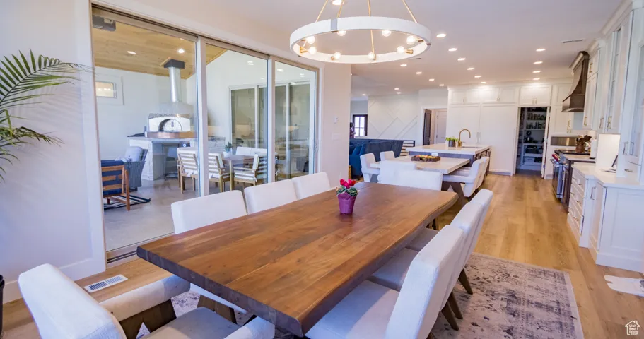 Dining room featuring light wood-style flooring, a chandelier, and recessed lighting