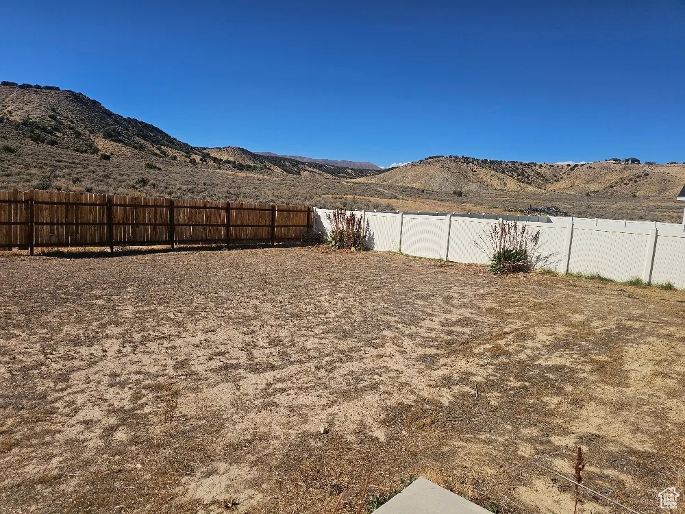 Fenced backyard featuring a mountain view