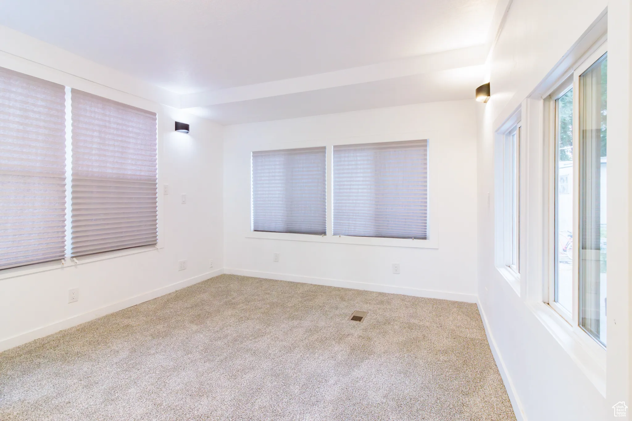 Empty room featuring baseboards and light colored carpet