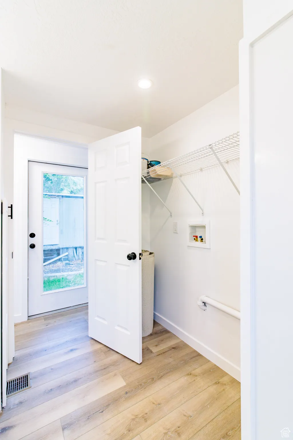 Washroom with light wood finished floors, hookup for a washing machine, and recessed lighting