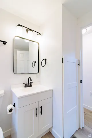 Half bathroom with vanity and light wood-style flooring