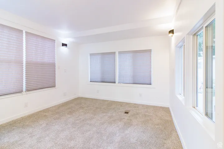 Empty room featuring baseboards and light colored carpet