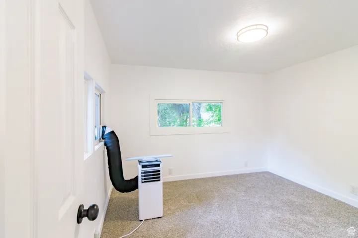 Carpeted empty room with baseboards