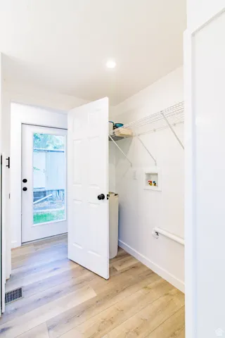 Washroom with light wood finished floors, hookup for a washing machine, and recessed lighting
