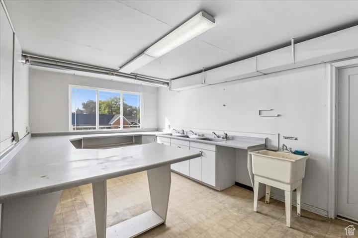 Commercial Kitchen with light countertops, light floors, and white cabinets