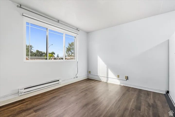 2 BR/2 BA Apartment Spare room with a baseboard heating unit and dark wood-style floors
