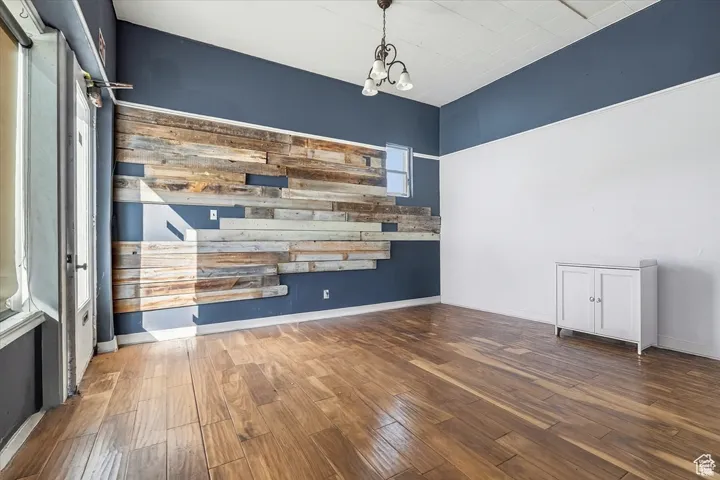 Separate Retail Space on SW corner featuring dark wood-style floors and a chandelier