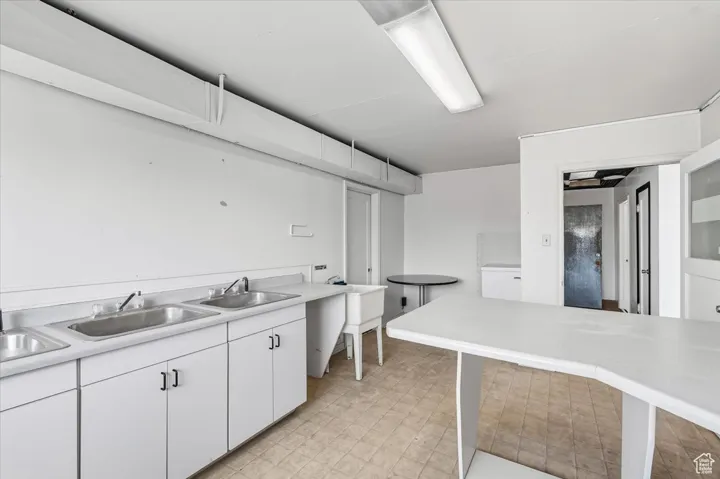 Commercial Kitchen featuring white cabinetry, light countertops, and light flooring