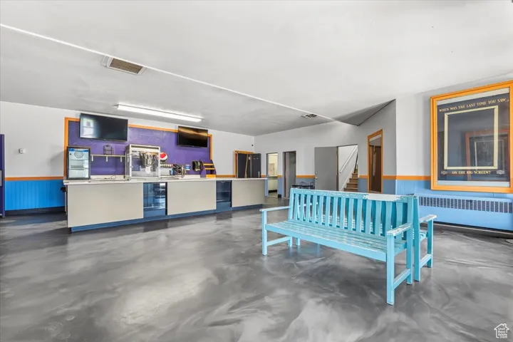 Theater Lobby featuring wainscoting, stairs, and wood walls