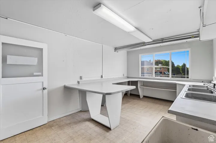 Commercial Kitchen featuring light floors, light countertops, a peninsula, and white cabinets