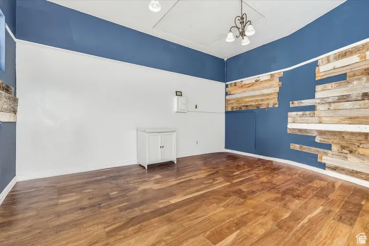 Separate Retail Space on SW corner featuring dark wood-style floors and a chandelier