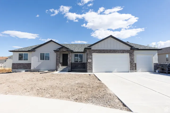 View of front of property with a garage, board and batten siding, and concrete driveway