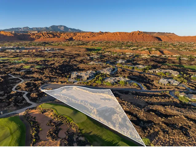 Expansive lot bordered by a golf course, surrounded by desert landscaping and distant mountains