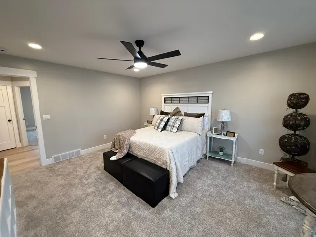 Bedroom with recessed lighting, a ceiling fan, and light carpet