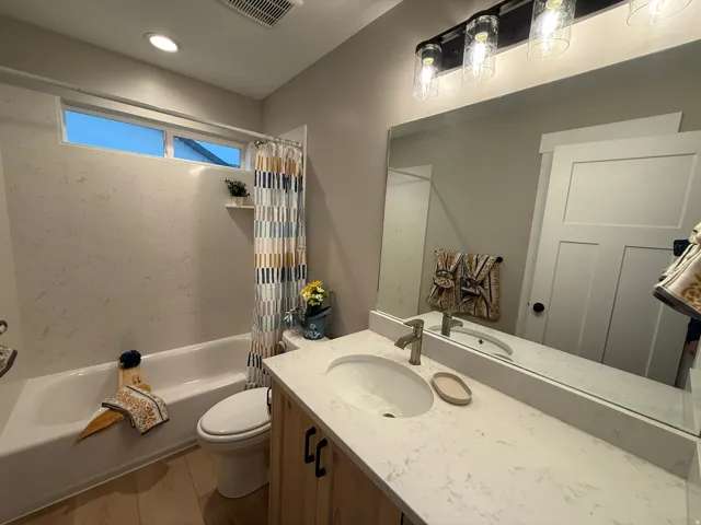 Bathroom with shower / bath combination with curtain, wood finished floors, and vanity