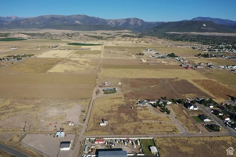 Aerial view of property and surrounding area featuring a mountainous background and rural landscape