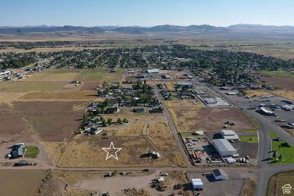 Aerial view of property and surrounding area featuring a mountain backdrop
