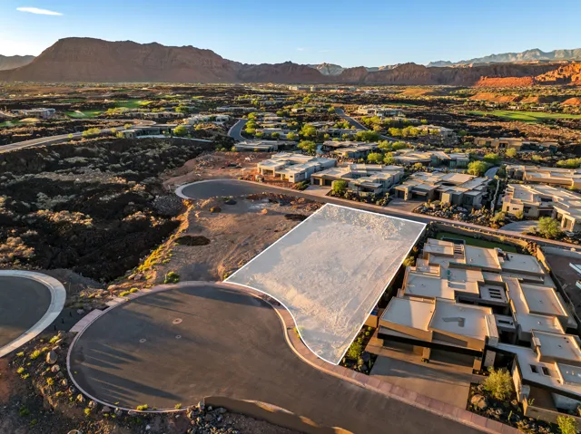 Vacant lot with mountain backdrop, surrounded by established residential properties and natural desert landscaping
