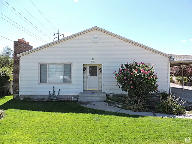 Bungalow-style house featuring a front lawn and a carport