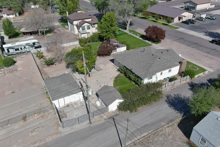 Main residential structure with a shingled roof, accompanied by a detached garage building
