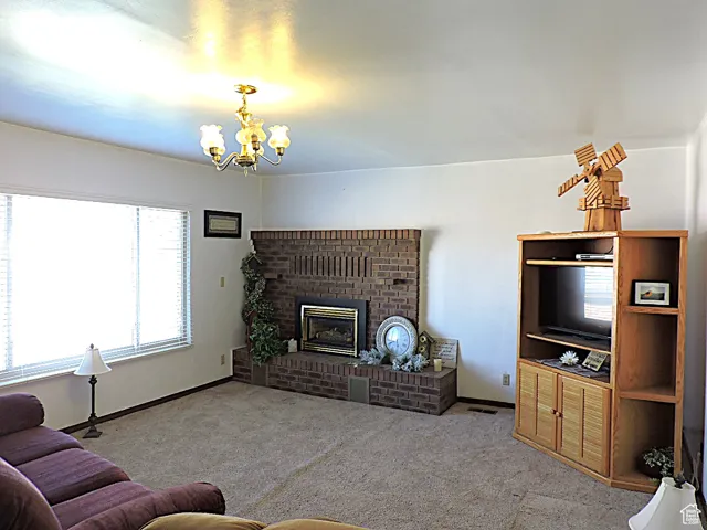 Living area with a brick fireplace, carpet