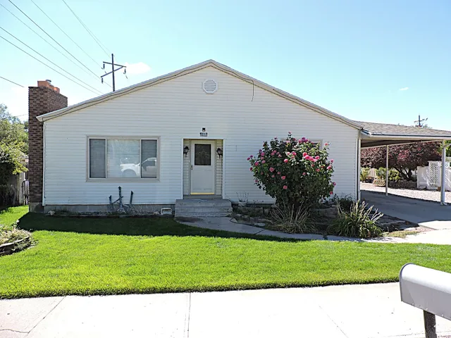 View of front of house featuring a front yard, a carport, and concrete driveway