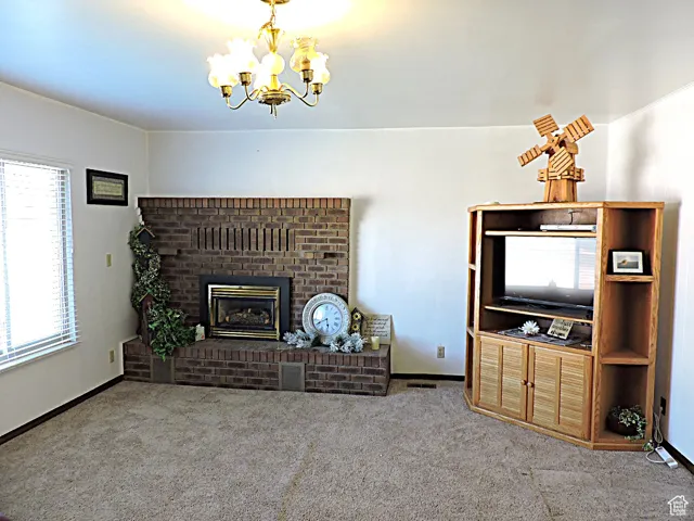 Carpeted living room featuring a brick fireplace