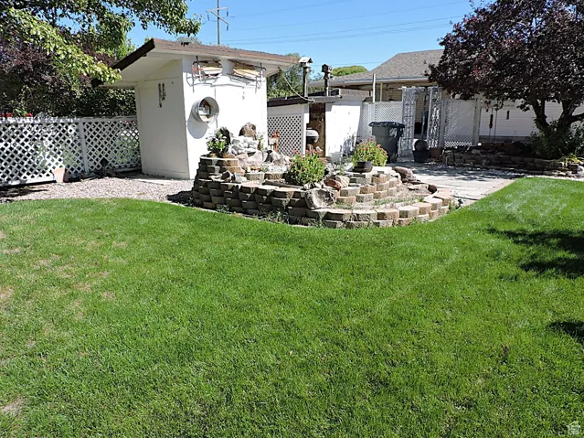 View of yard featuring a patio and an outbuilding