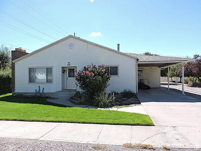 View of front of house featuring a carport, driveway, and a front lawn