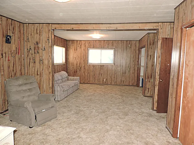 Unfurnished room featuring wood walls