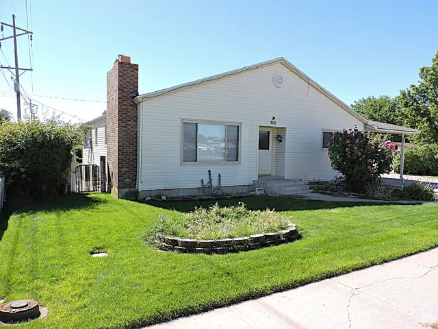 View of front facade with a chimney and a front lawn