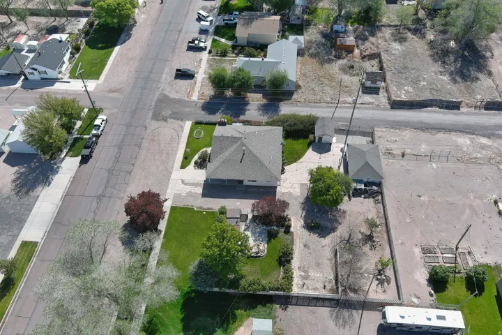 Aerial property view featuring a main residence with an attached garage, a separate detached garage, and a shed