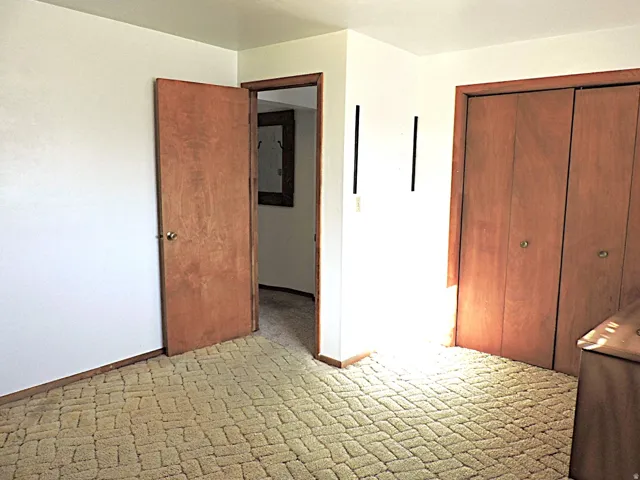 Unfurnished bedroom with a closet and light carpet