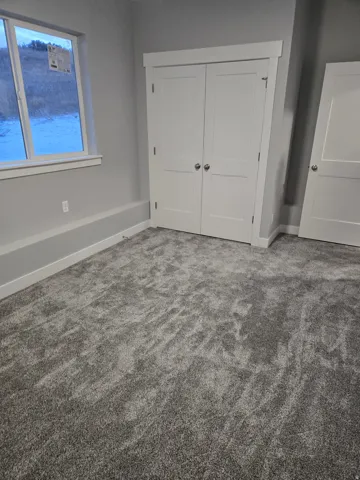 Unfurnished bedroom featuring a closet and carpet