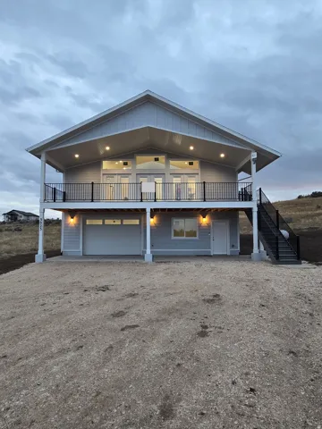 View of front facade with driveway, stairway, and a patio area