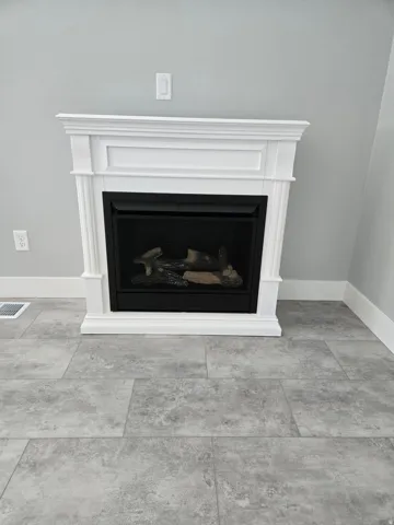 Detailed view of a fireplace and baseboards