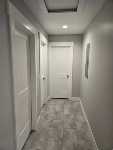 Hallway with recessed lighting and electric panel