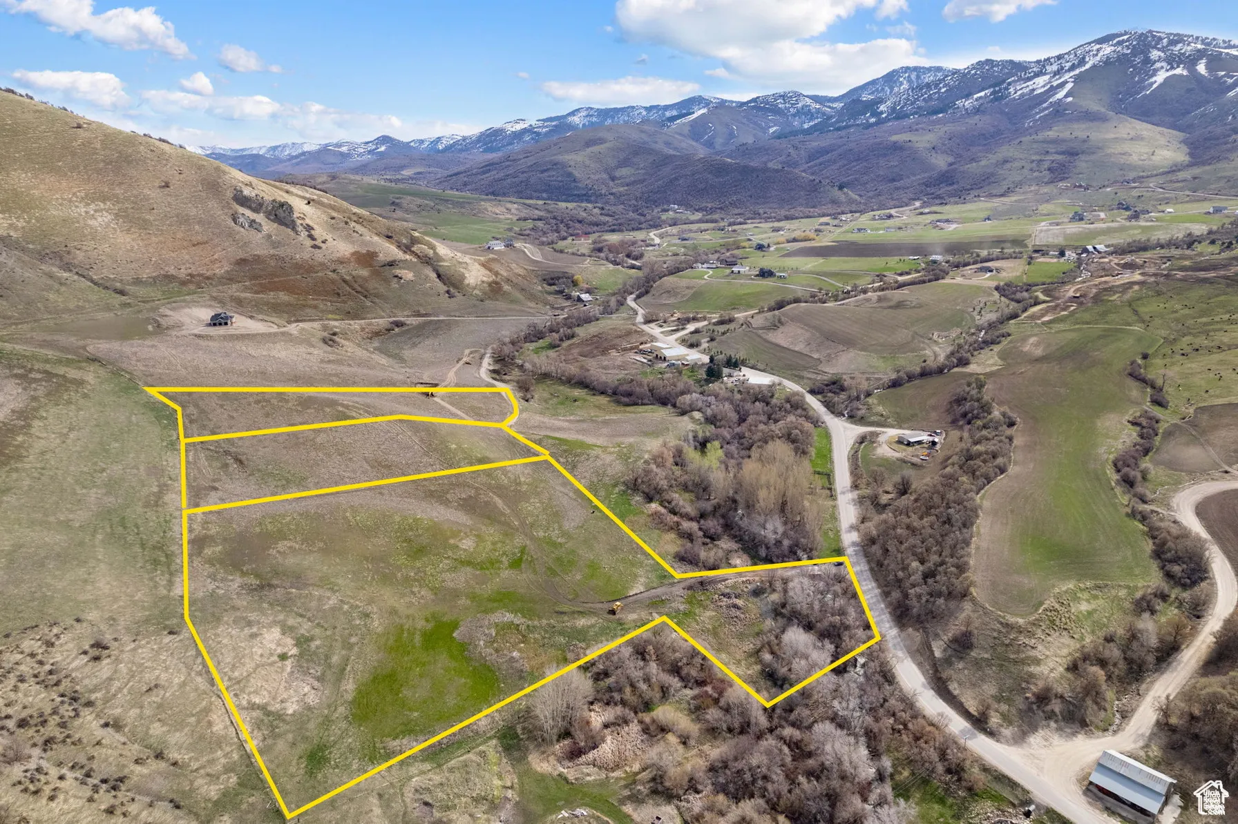 Overview of rural landscape featuring a mountainous background and property boundaries highlighted