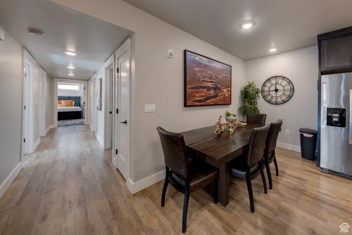 Dining room with light wood-type flooring and recessed lighting