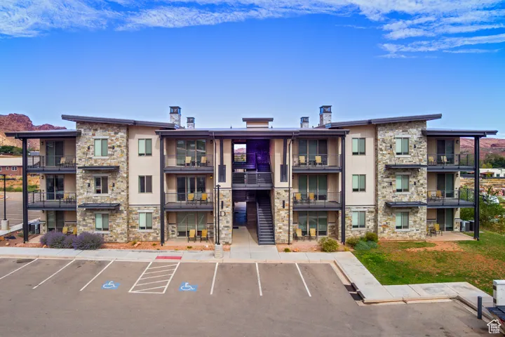 View of building exterior featuring uncovered parking