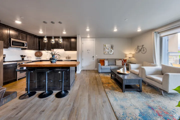 Living room with light wood-style flooring and recessed lighting