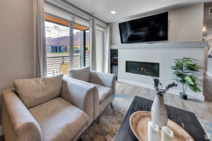 Living area featuring wood finished floors and a glass covered fireplace