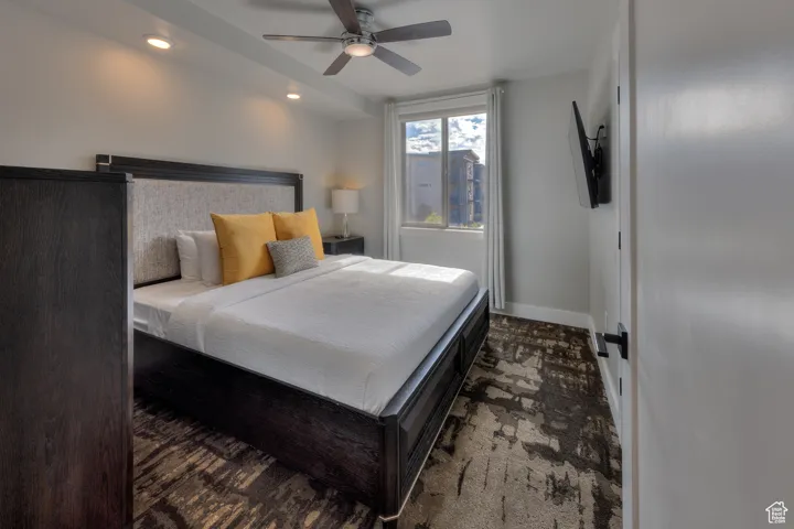 Bedroom featuring ceiling fan, recessed lighting, and dark colored carpet