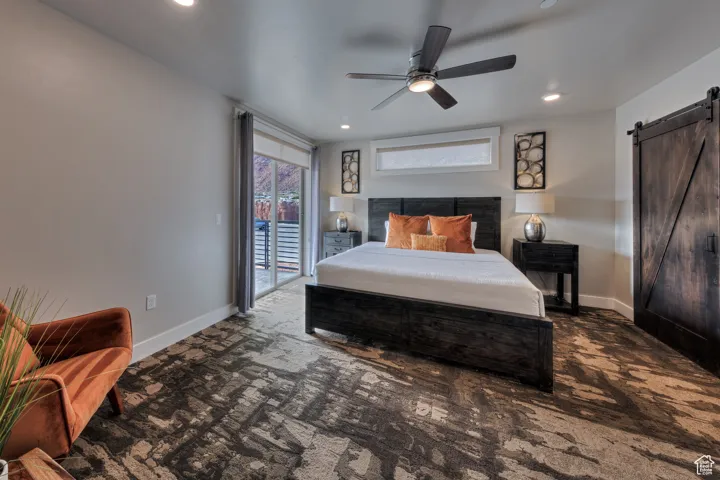 Bedroom with a barn door, access to exterior, carpet flooring, recessed lighting, and a ceiling fan