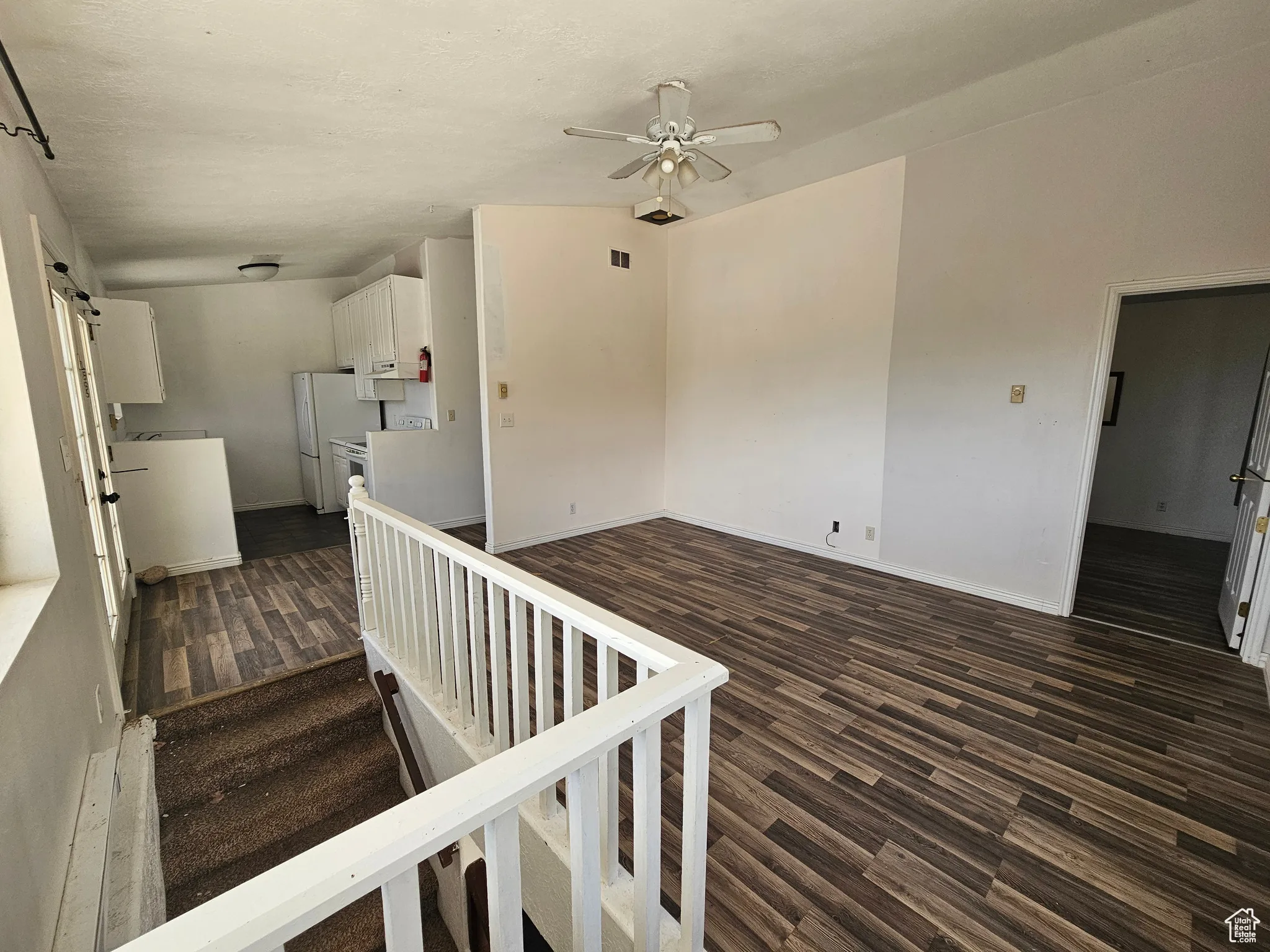 Staircase with wood finished floors, a barn door, and a ceiling fan