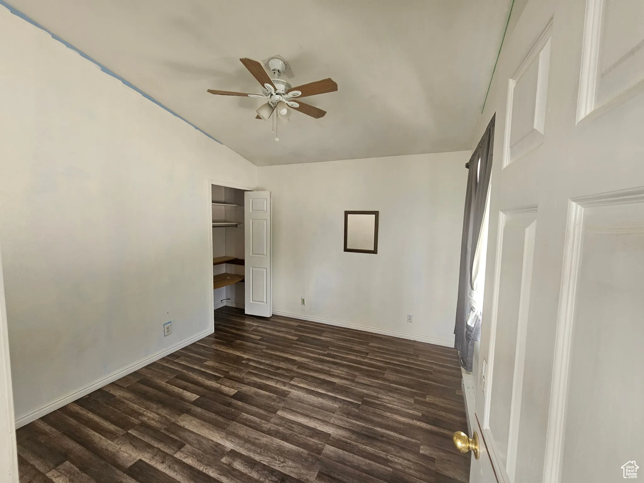 Unfurnished bedroom featuring dark wood-style flooring and ceiling fan