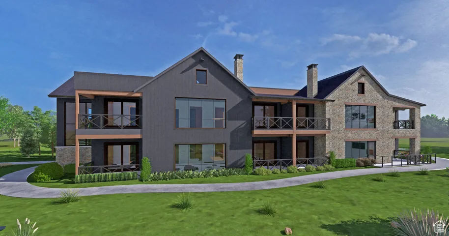 Rear view of house with a balcony, a chimney, stone siding, and a yard