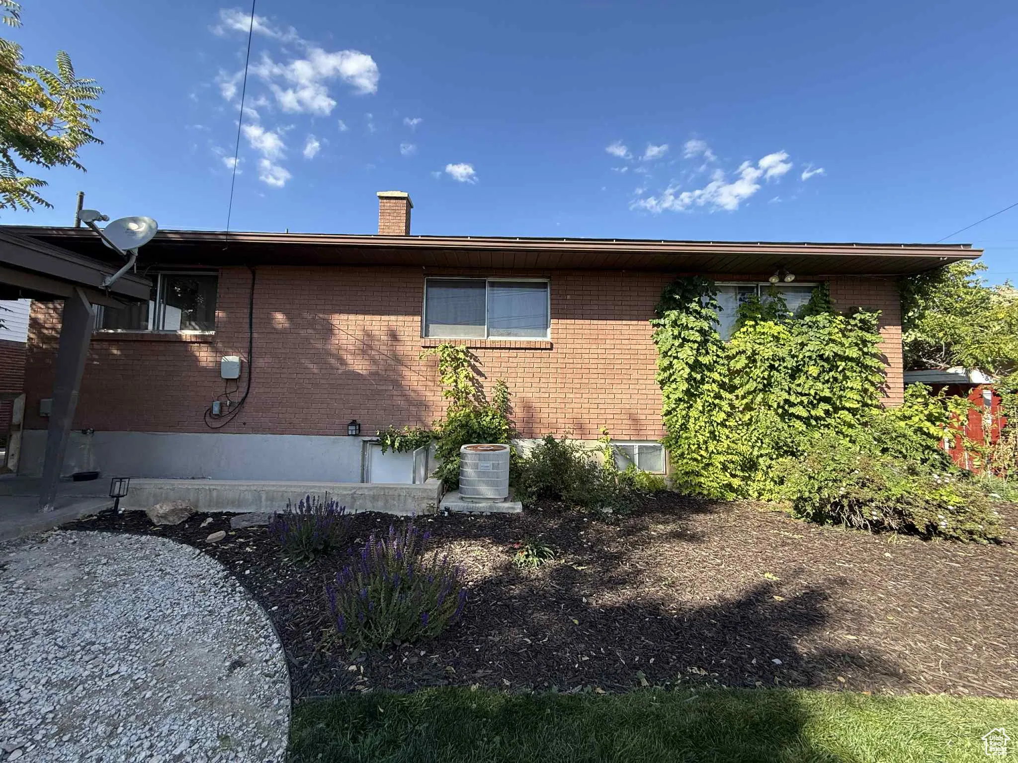 View of home's exterior with a chimney and brick siding